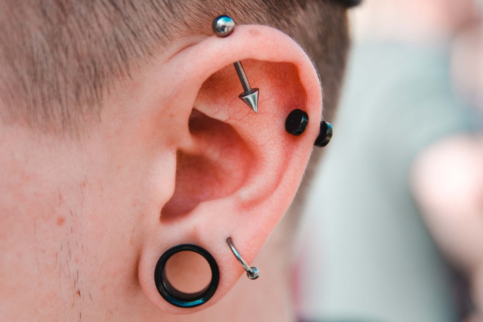 Muž s mnohými piercingmi v uchu
